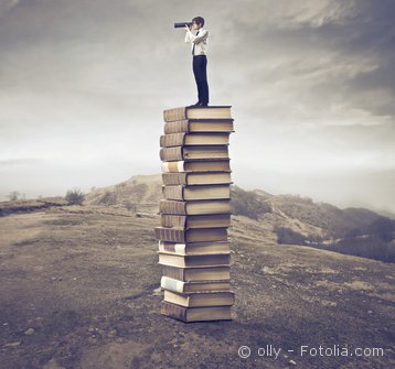 Foto Mann mit Fernglas auf Büchern